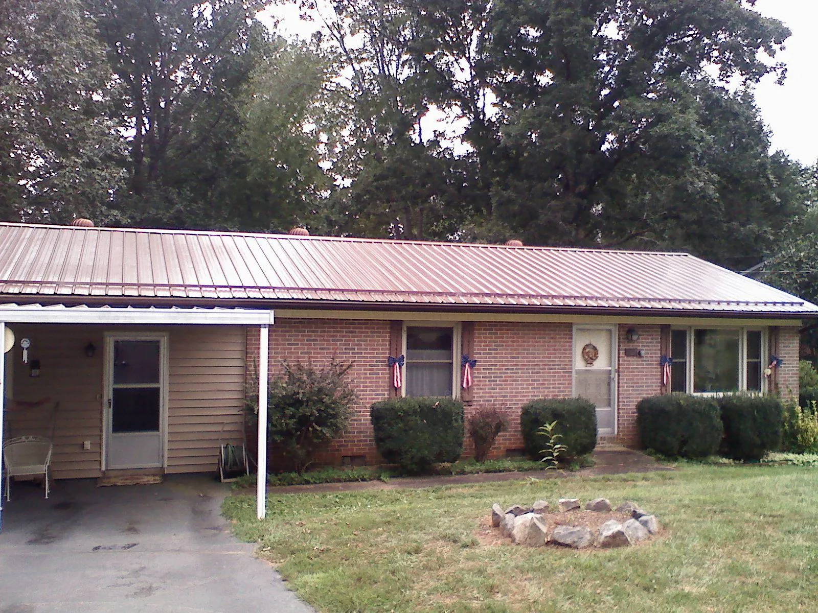 Bronze metal roof and carport on a brick ranch home — Roof Repair work by our crew in Willow Wood
