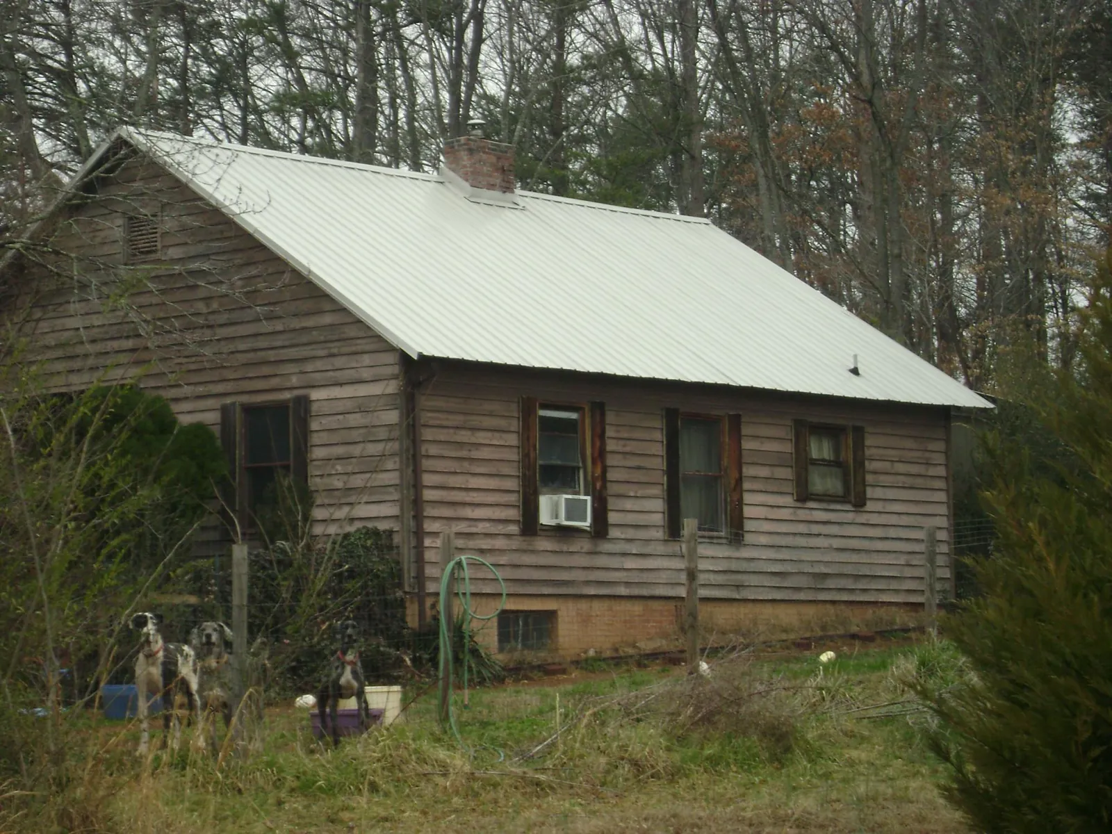 White metal roof on an old wood sided farmhouse, from a Metal Roof Installation job in Willow Wood